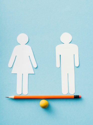 paper figures of couple as gender equality on pencil with ball isolated on blue, sexual equality paper figures of couple as gender equality on pencil with ball isolated on blue, sexual equality